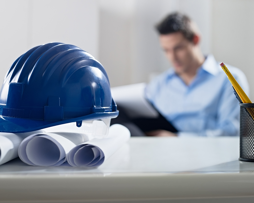 Capacete azul em cima de uma mesa com um homem ao fundo